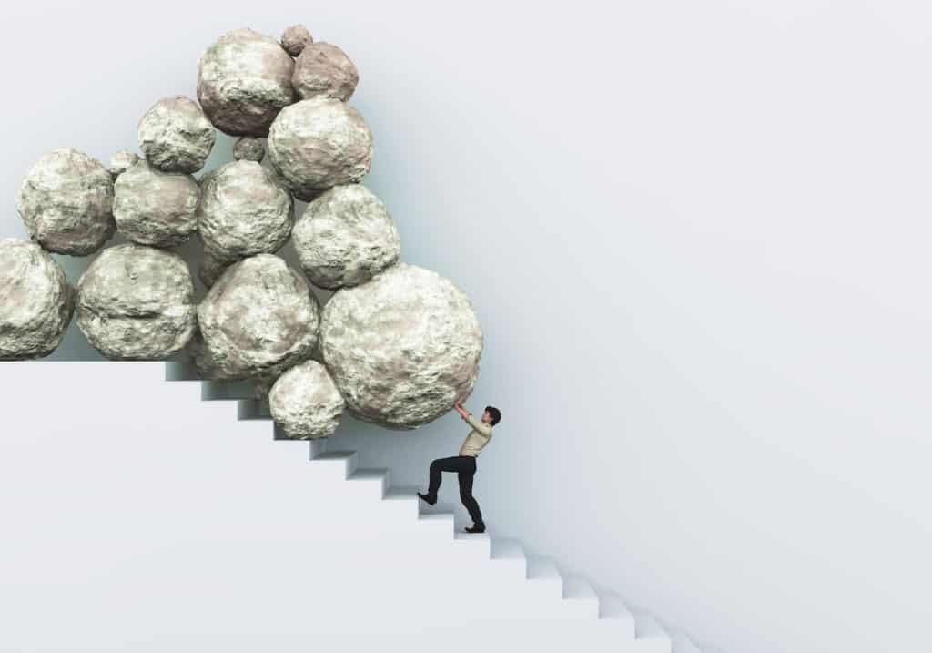 Man pushing pile of rocks up stairs